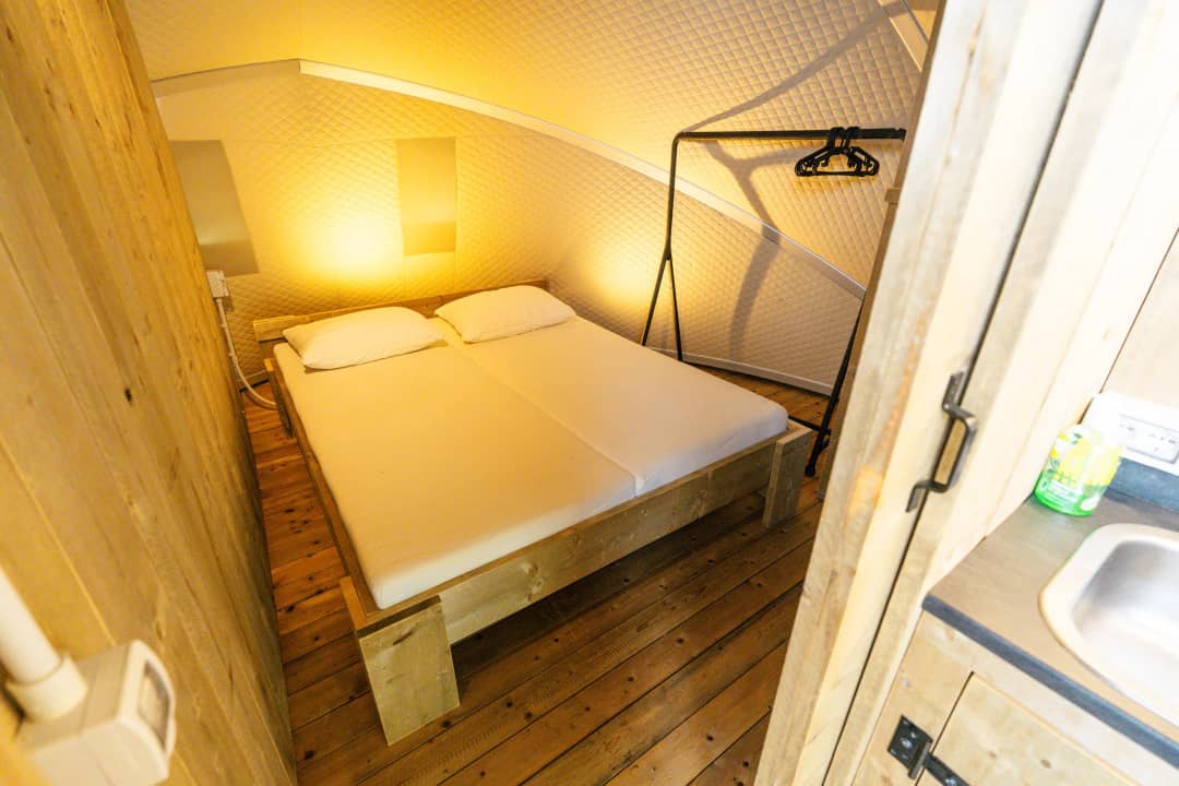Schlafzimmer mit Doppelbett und Holzwänden