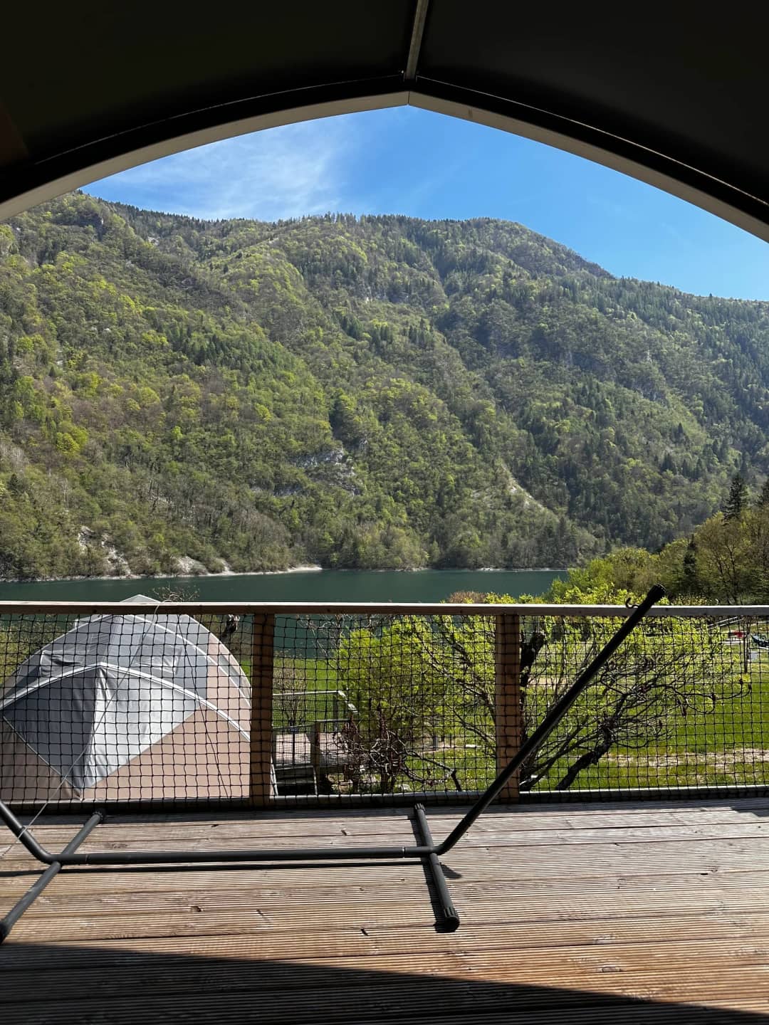 Blick von der überdachten Veranda der Big Oak Lodge XL auf den See und die bewaldeten Berghänge