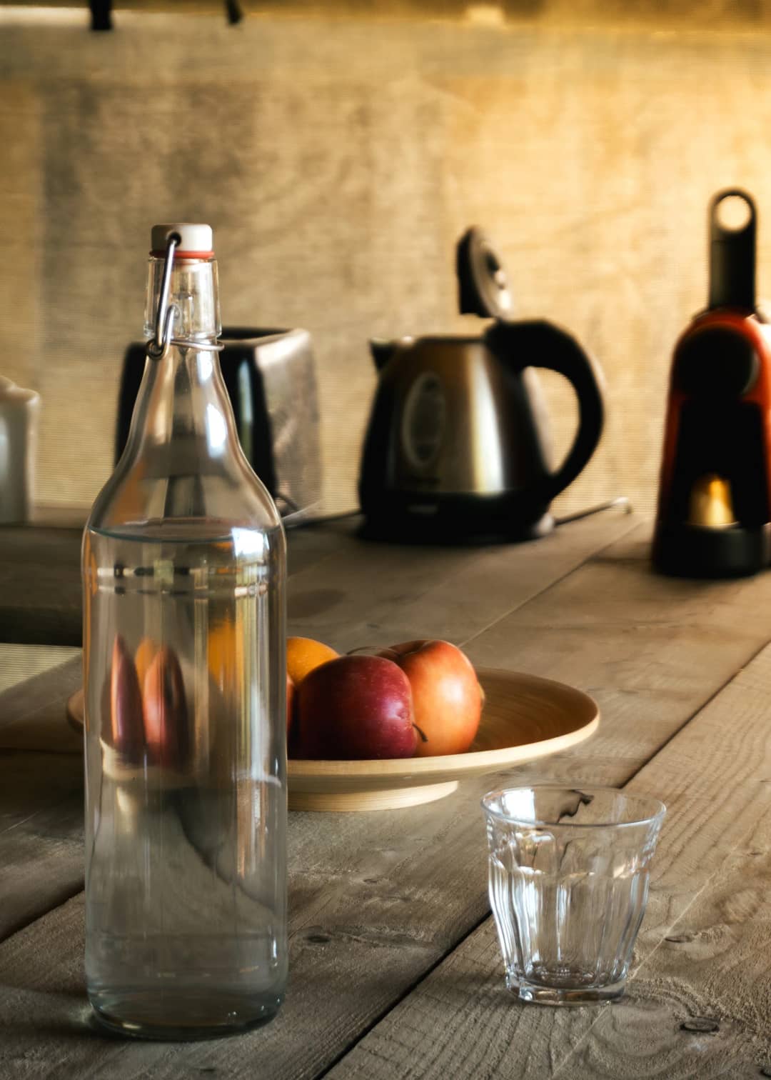 Tisch mit Wasserkaraffe, Obst und Wasserkocher