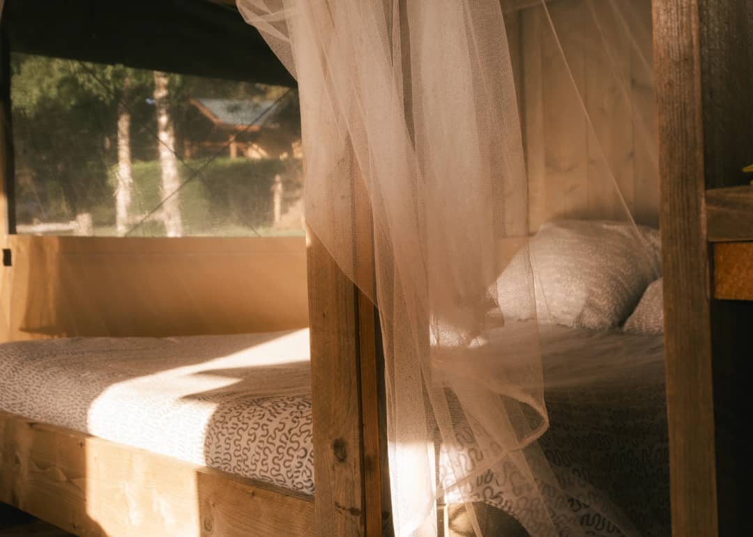 Das Bett hinter dem Moskitonetz im Morgenlicht